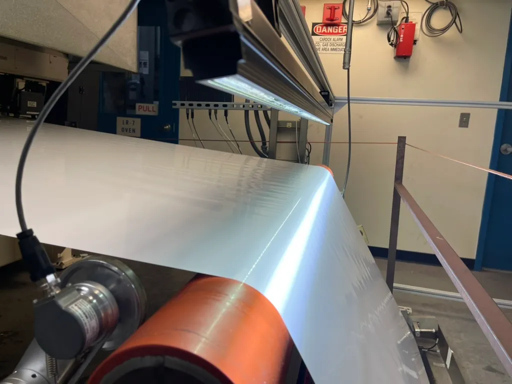 A Shelfmark inspection camera mounted over a moving industrial film line